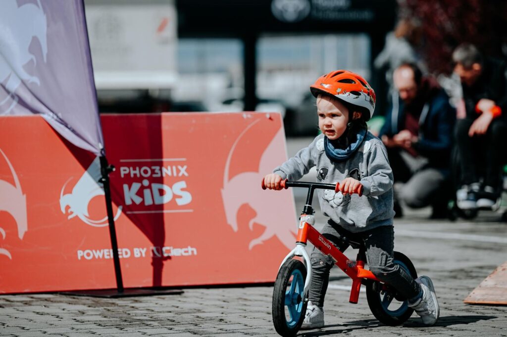 Mały chłopiec jadący na rowerku podczas zajęć w ramach Pikniku Pho3nix Academy